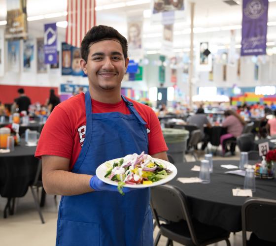 family-dining-room-vso Young man standing in a dining room holding a plate of vegetables
