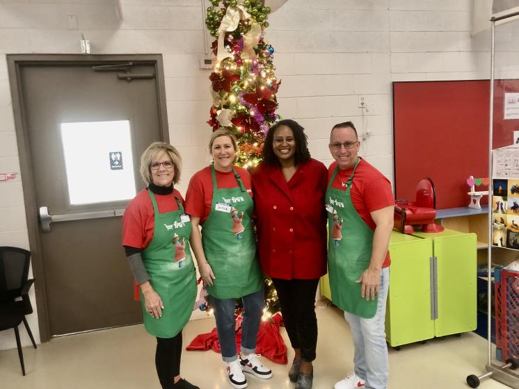 Fry's Foundation Four people posing in front of a Christmas tree